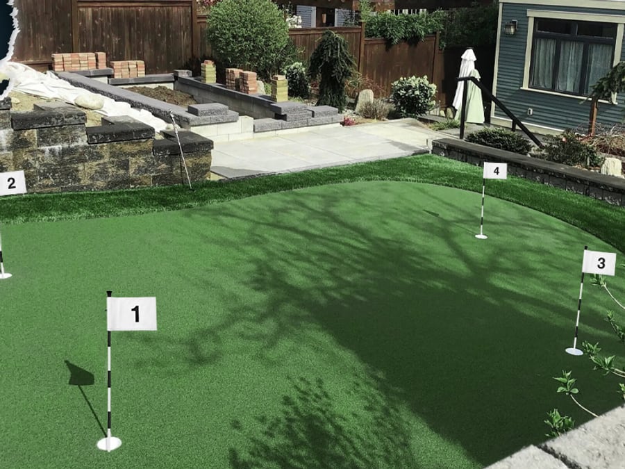 A backyard putting green with numbered KINGTOP flags standing in four cut holes